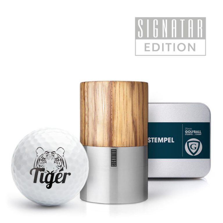 Golfstempel AG25 mit Zebranoholz-Griff in Box, neben einem Golfball